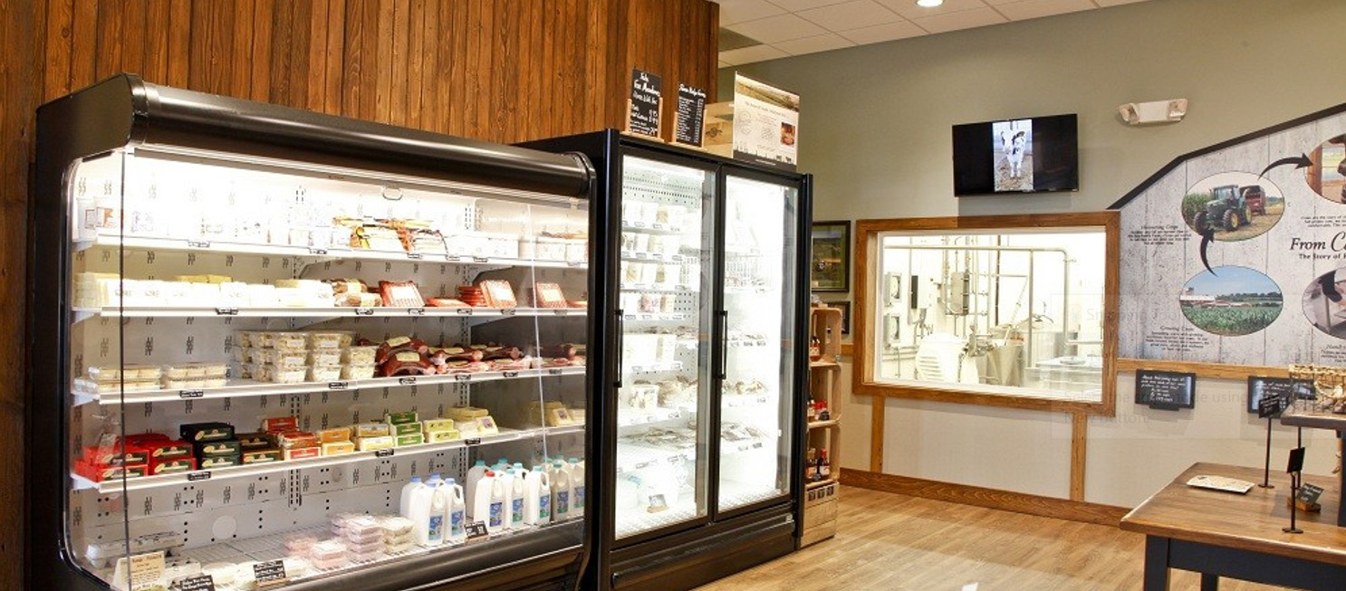 A store with refrigerators containing dairy products 