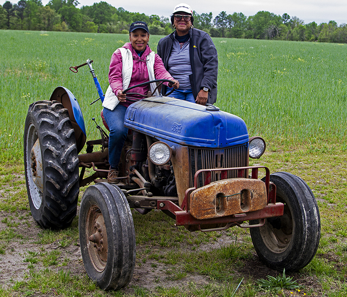 Two people sitting on old rusted tractor