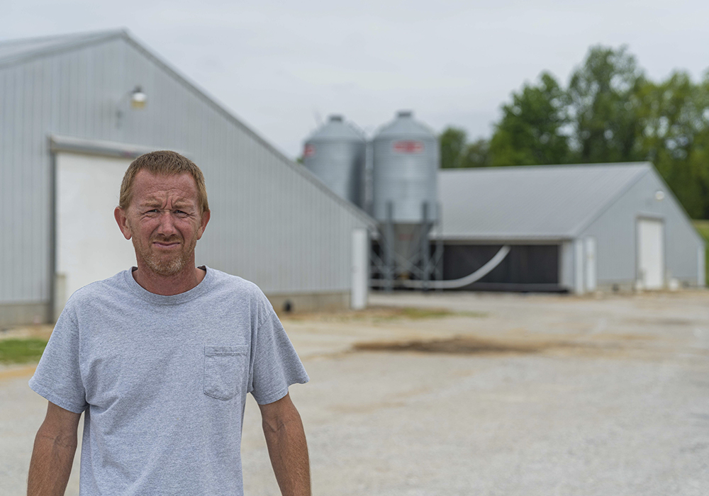 Person standing in front of two feed houses