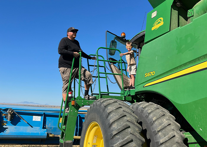 Two people standing on tractor