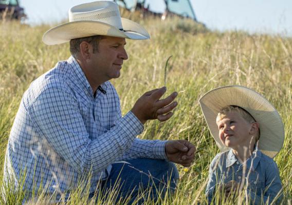 Britton Blair teaches his son Jack how to identify different grass species on their South Dakota ranch 