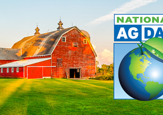 Big red barn sitting in an open field of green grass and trees. Ag Day logo on top of image.