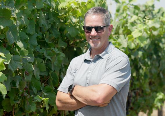 Person standing next to vines