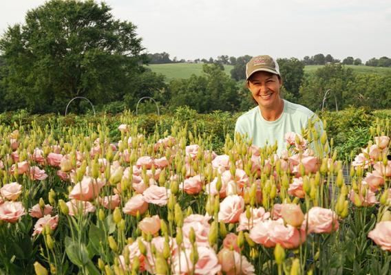 Person kneeling in field of flowers