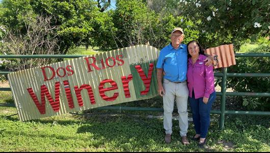 Two people standing in front of Dos Rios Winery sign