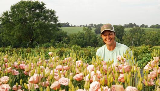 Person kneeling in field of flowers